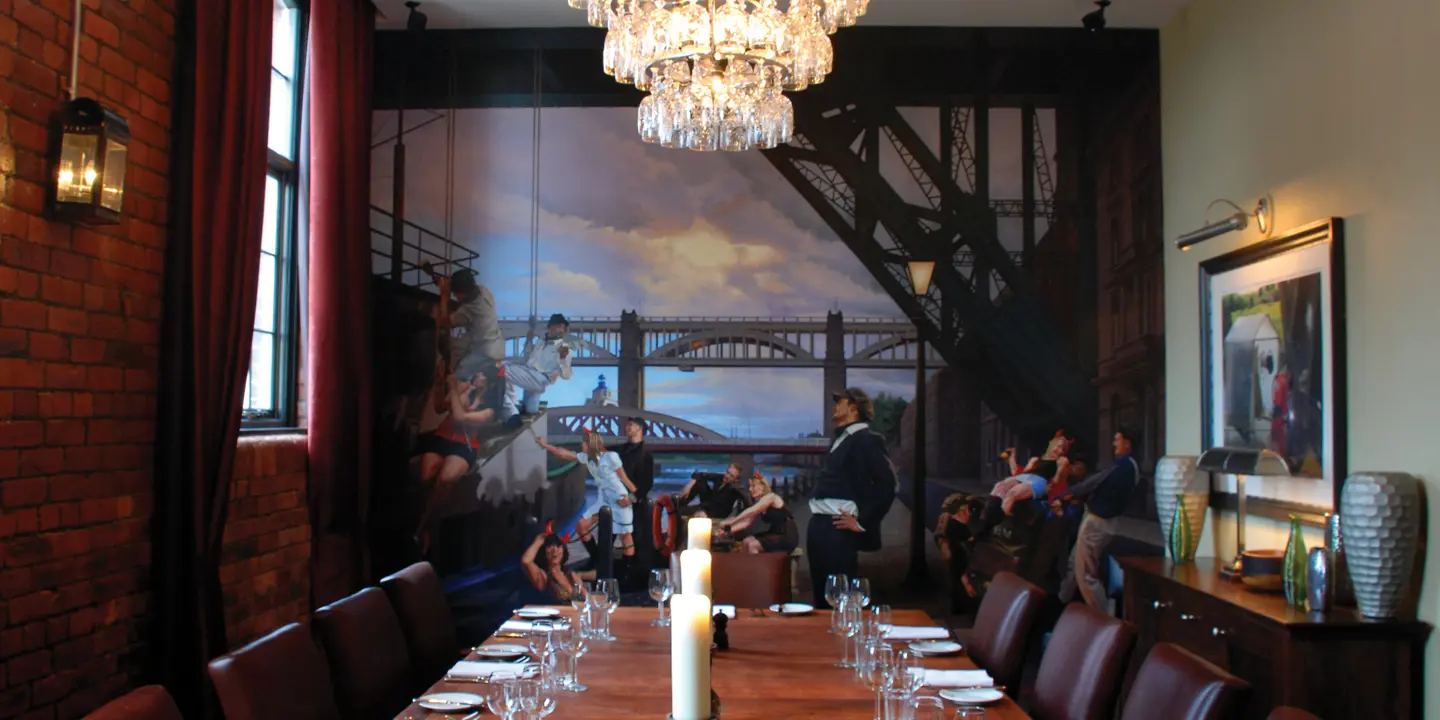A dining room featuring a lengthy table adorned with an elegant chandelier.