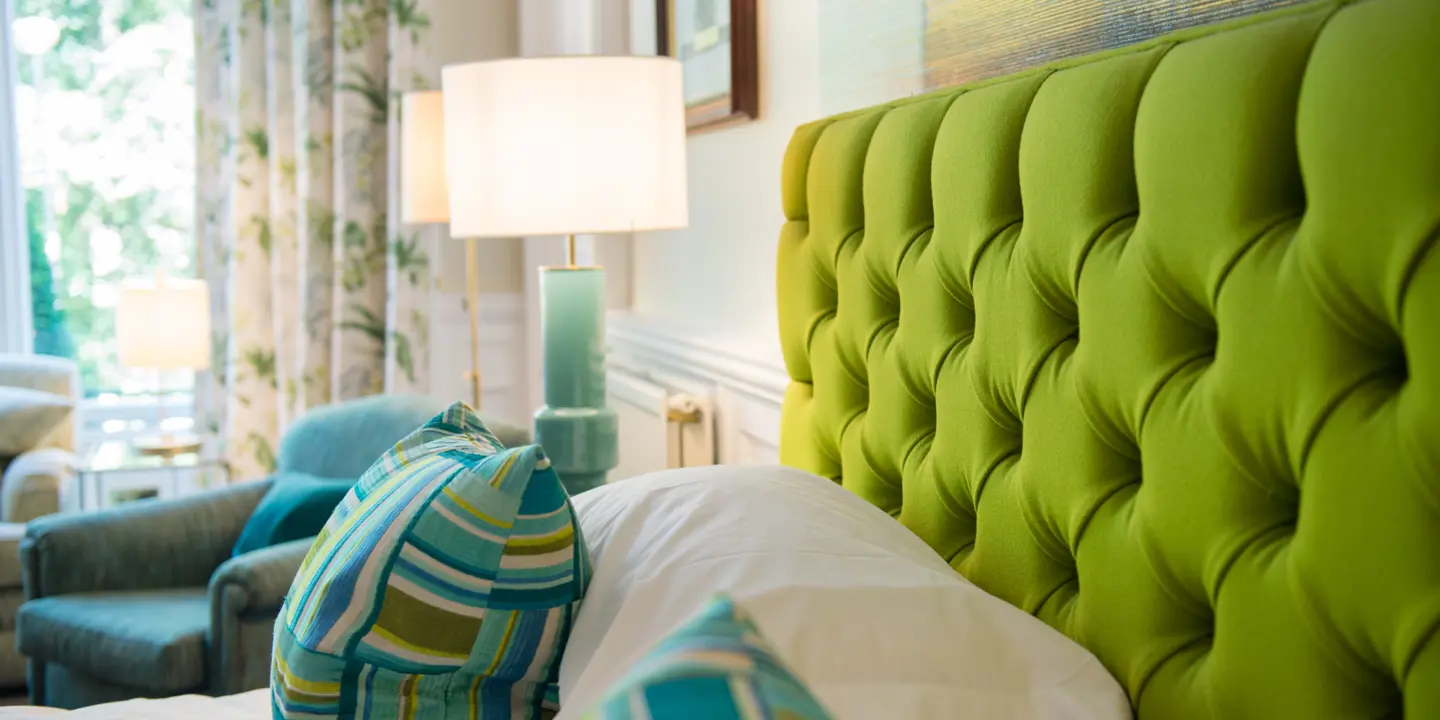 Green headboard and pillows on a bed.