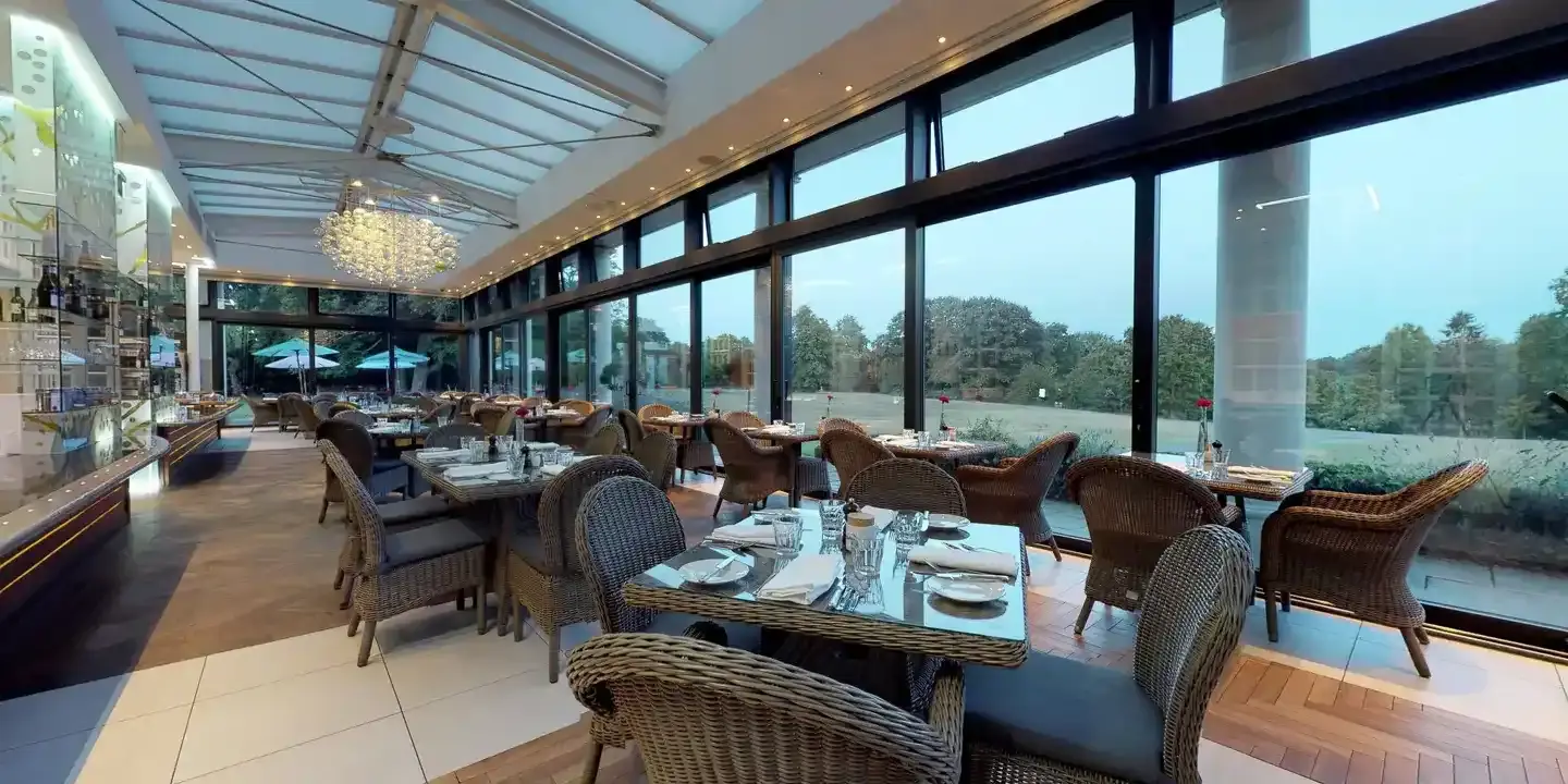 A restaurant featuring expansive windows that offer picturesque views of a golf course.