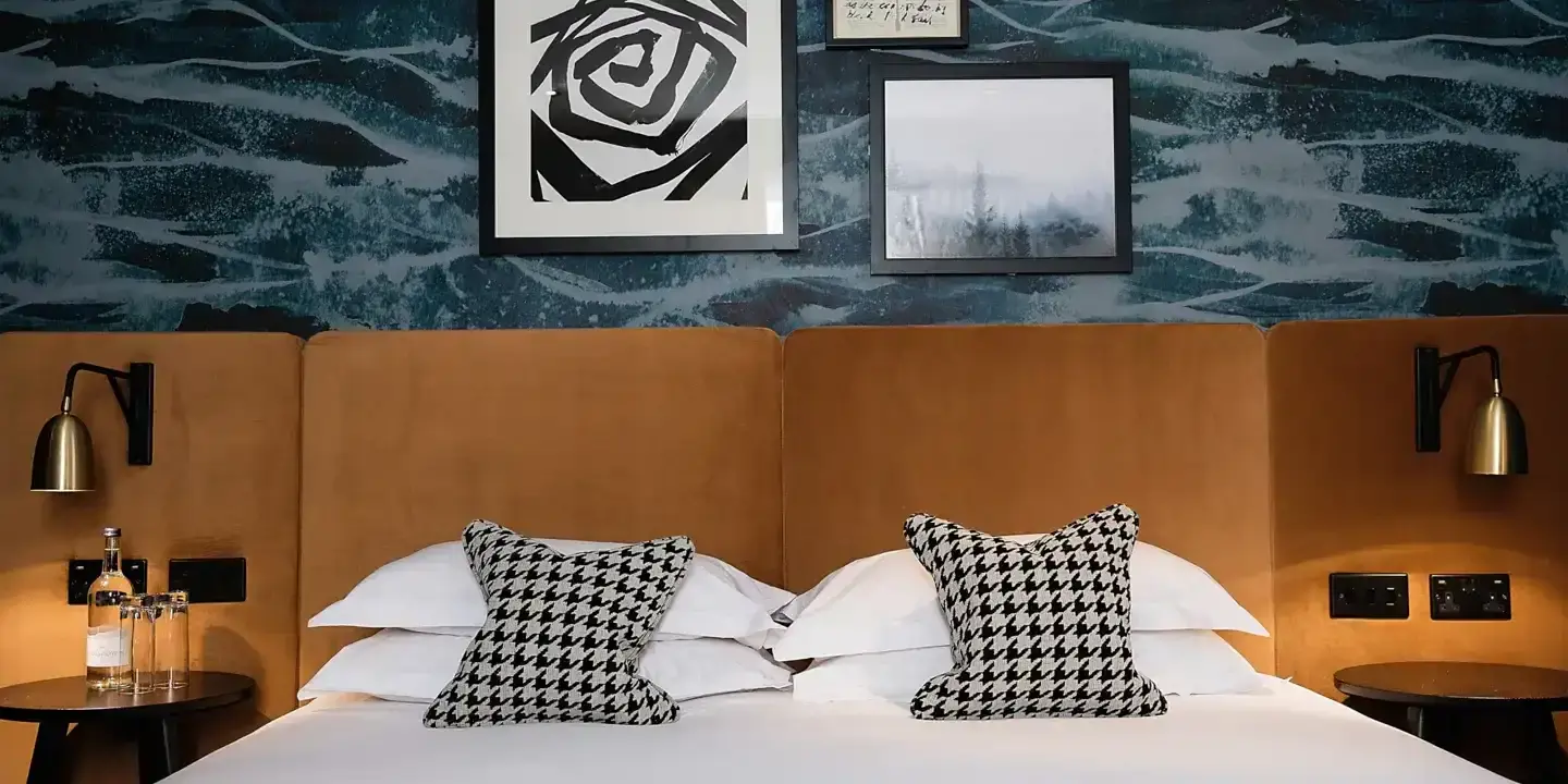 An elegantly made bed adorned with two plump pillows and a tastefully framed picture hanging on the wall.