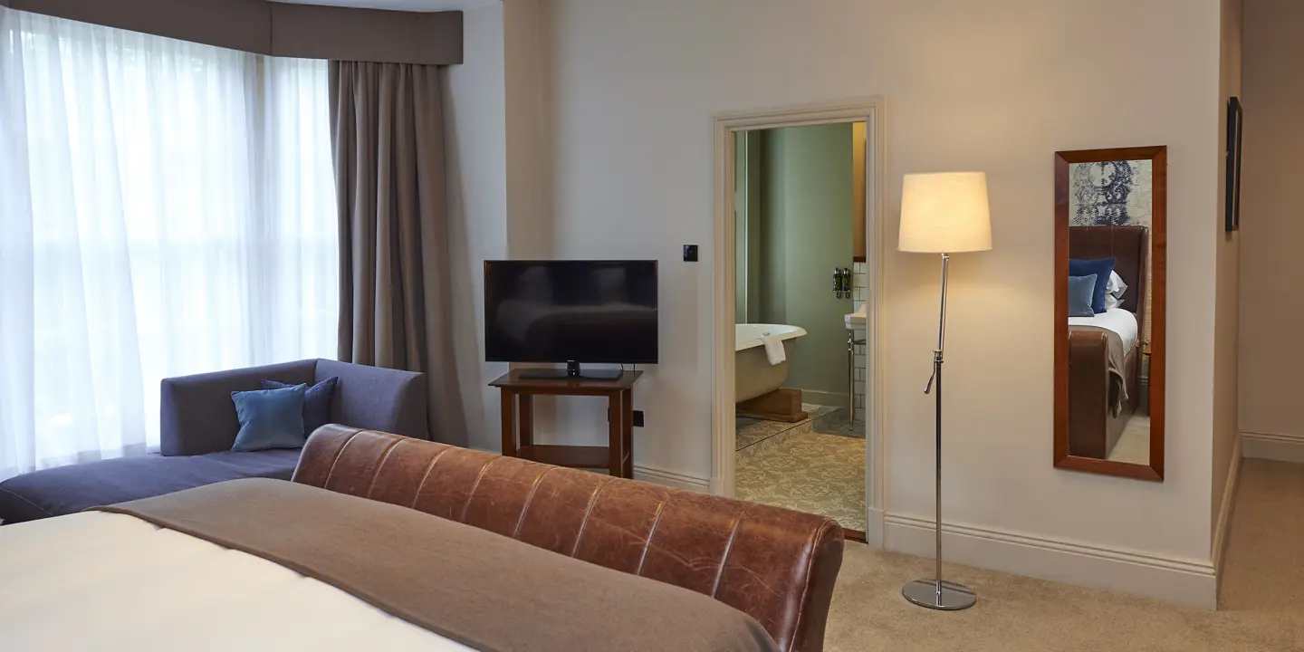 Spacious room with a bed leading the bathroom
