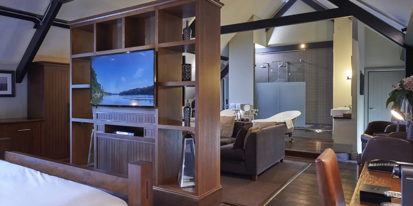 Spacious bedroom featuring a large flat-screen TV.