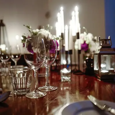Wooden table adorned with wine glasses and silverware.