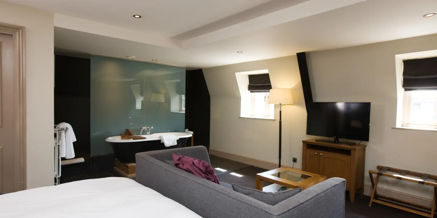 An elegantly furnished living room featuring a comfortable couch, a sleek television, and an exquisite bathtub.