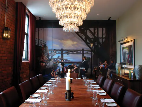 A dining room featuring a lengthy table adorned with an elegant chandelier.