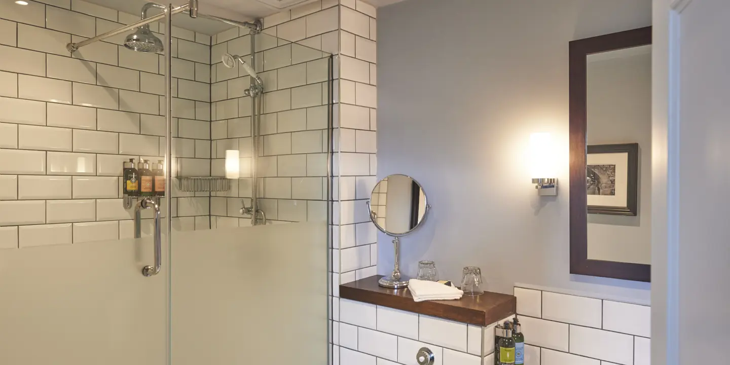 A bathroom featuring a shower, sink, and mirror.