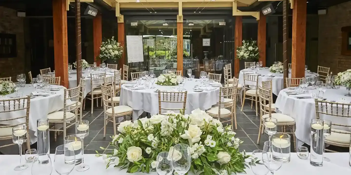 A room furnished with tables, chairs, and adorned with flowers.