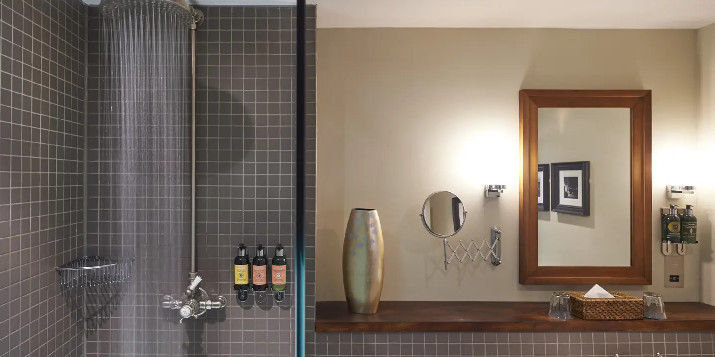 Bathroom featuring a shower, sink, and mirror.