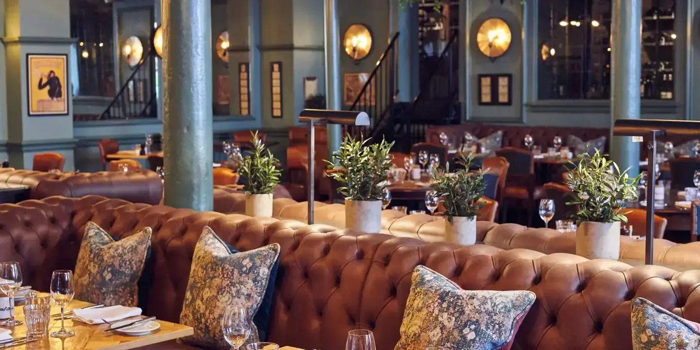 A spacious dining room filled with numerous cushions and plant pots