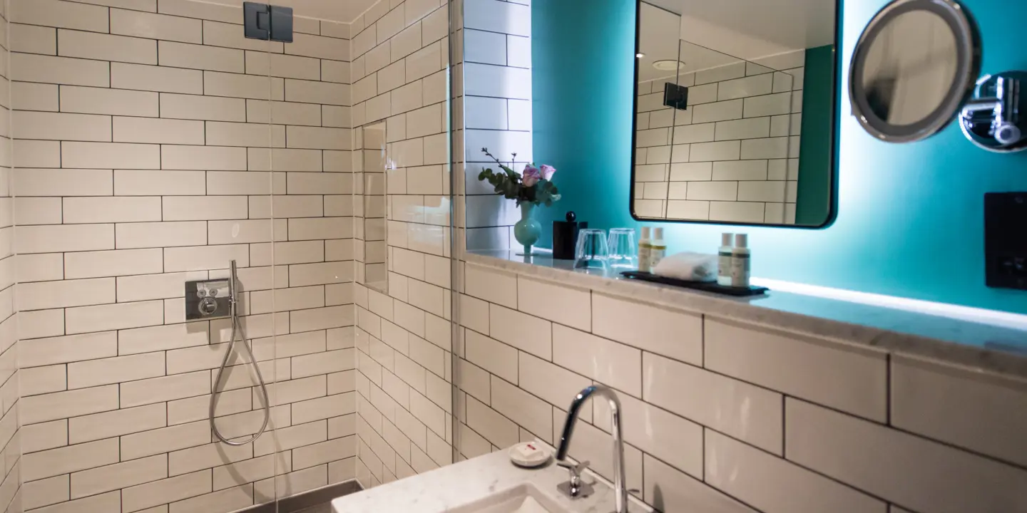 Bathroom featuring a sink, mirror, and shower.