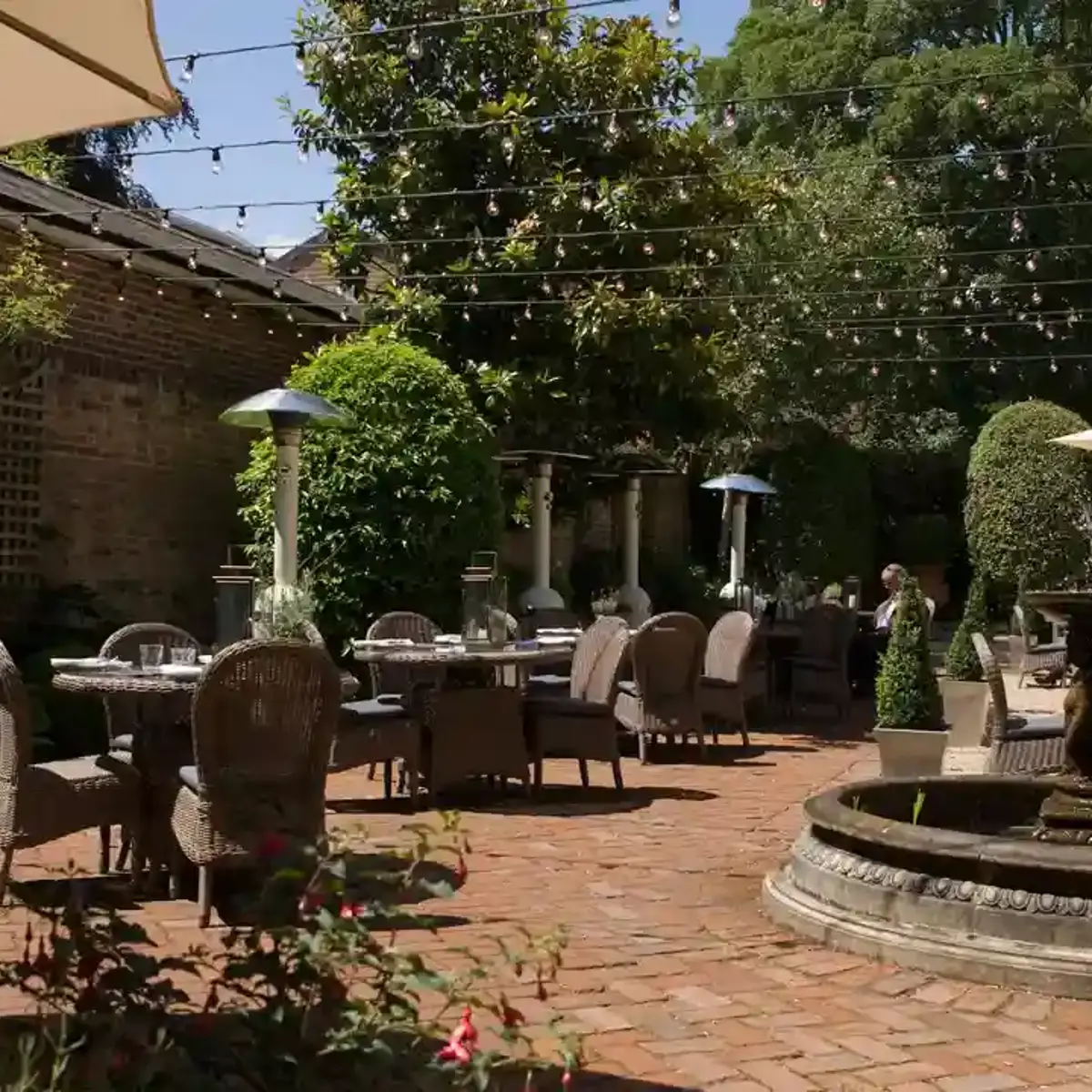 A patio featuring tables, chairs, and umbrellas.