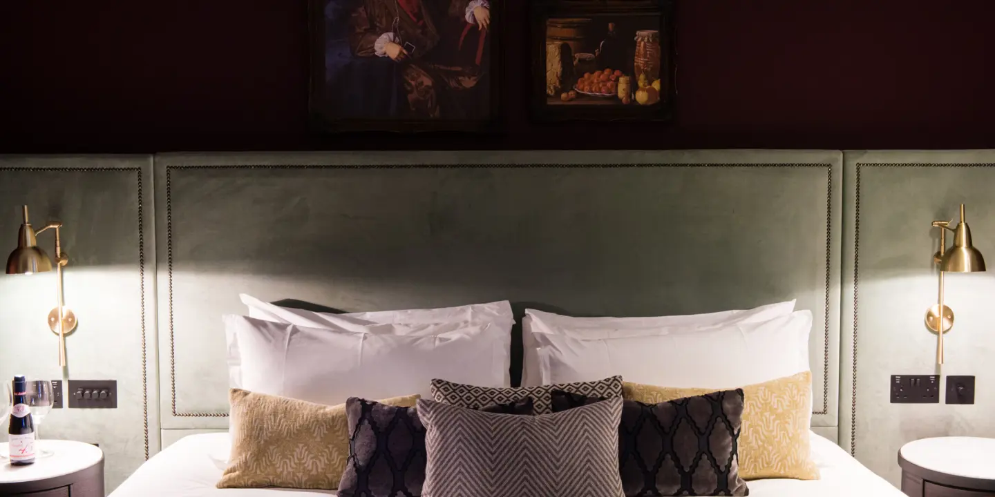 Bedroom featuring a comfortable bed with two lamps positioned on either side.