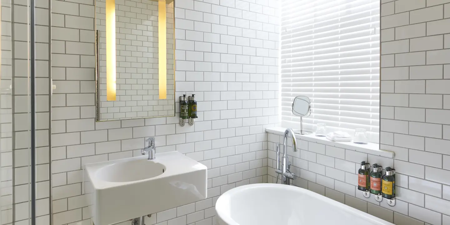 A bathroom featuring a bathtub, sink, and mirror.