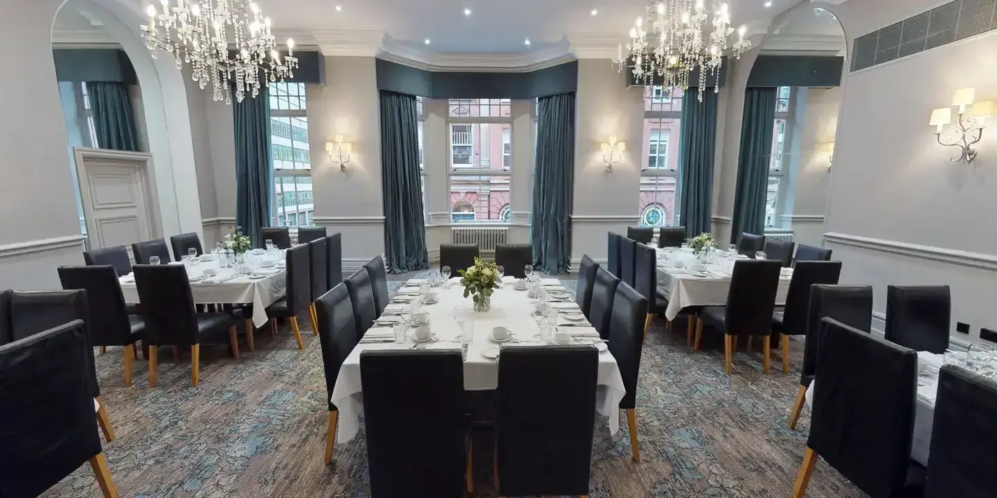 A dining room featuring elegantly arranged tables and chairs, adorned with exquisite chandeliers.