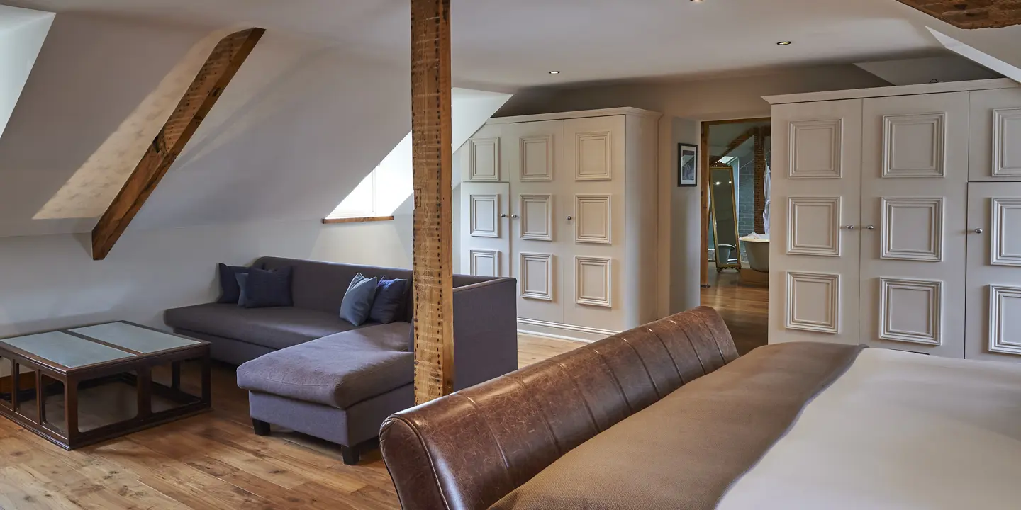 An elegantly furnished bedroom featuring a comfortable couch and a cozy bed.