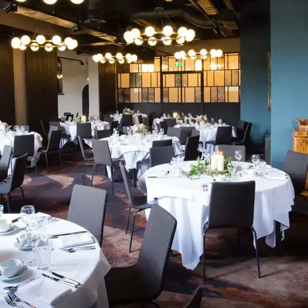 A restaurant arranged with elegantly set tables and chairs for a delightful dinner experience.