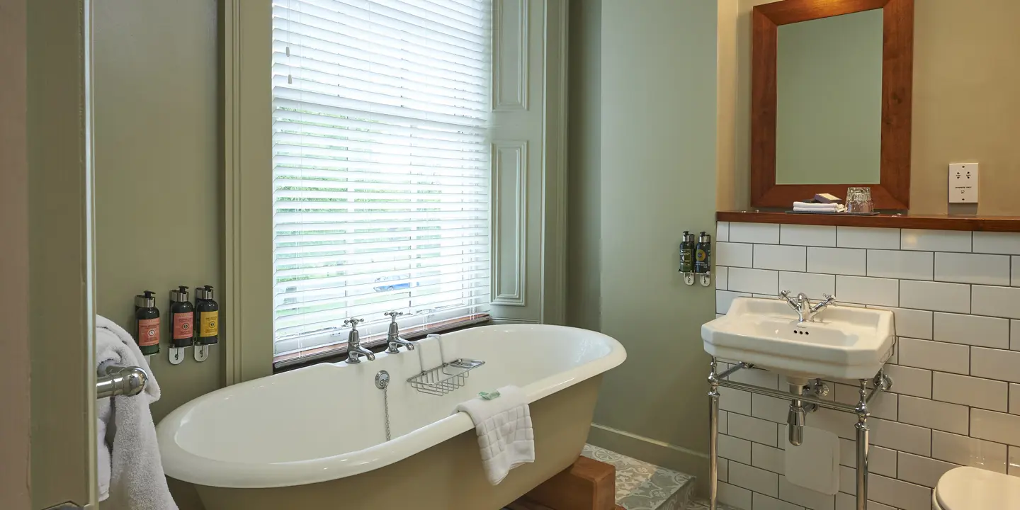 Spacious bath under the window with a sink and mirror