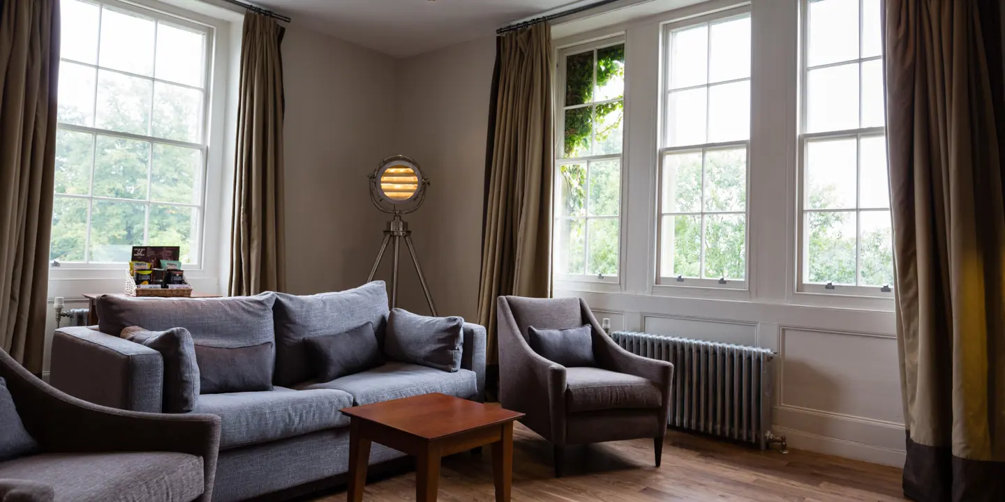 A well-furnished living room with ample natural light streaming through the windows.