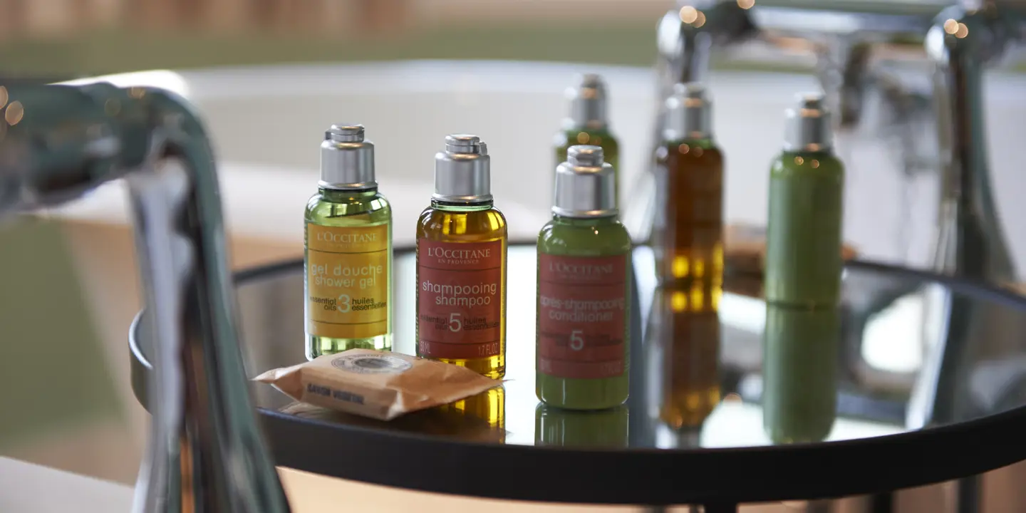 Glass table adorned with bottles and soaps.