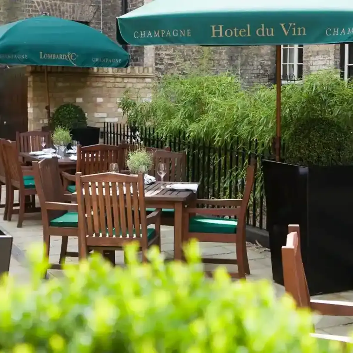 A patio featuring tables, chairs, and umbrellas.
