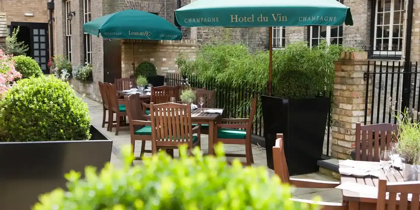 A patio featuring tables, chairs, and umbrellas.