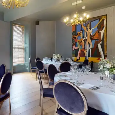 Dining room with round back chairs and gold chandelier