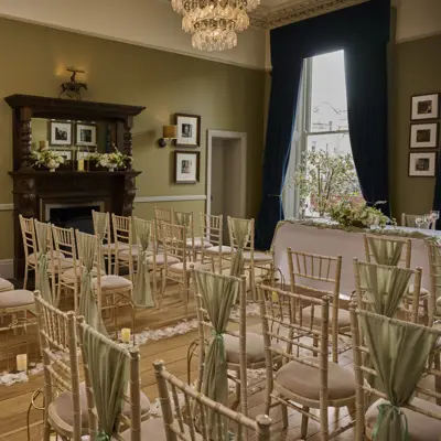 An elegantly furnished room with chairs, a table, and a beautiful chandelier.