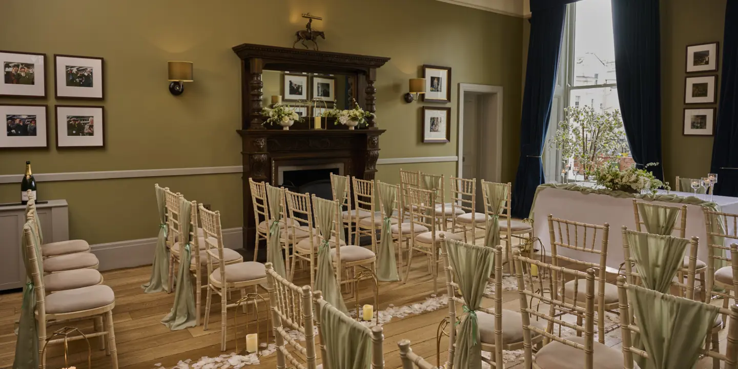 An elegantly furnished room with chairs, a table, and a beautiful chandelier.