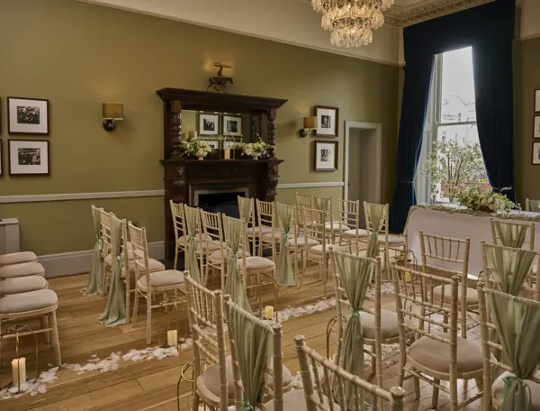 An elegantly furnished room with chairs, a table, and a beautiful chandelier.