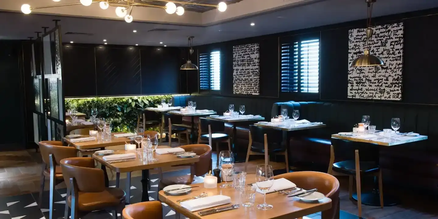 A restaurant featuring tables, chairs, and a bar.