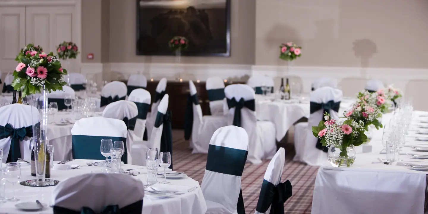 A room adorned with tables draped in pristine white linens.