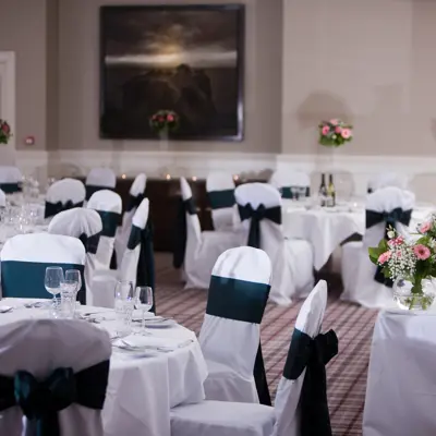 A room adorned with tables draped in pristine white linens.