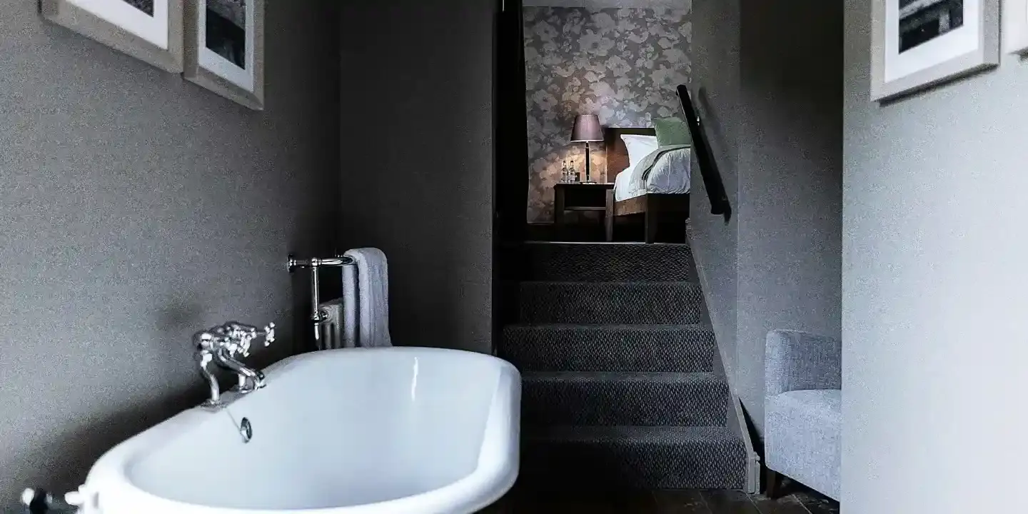 A bathtub positioned alongside a staircase.