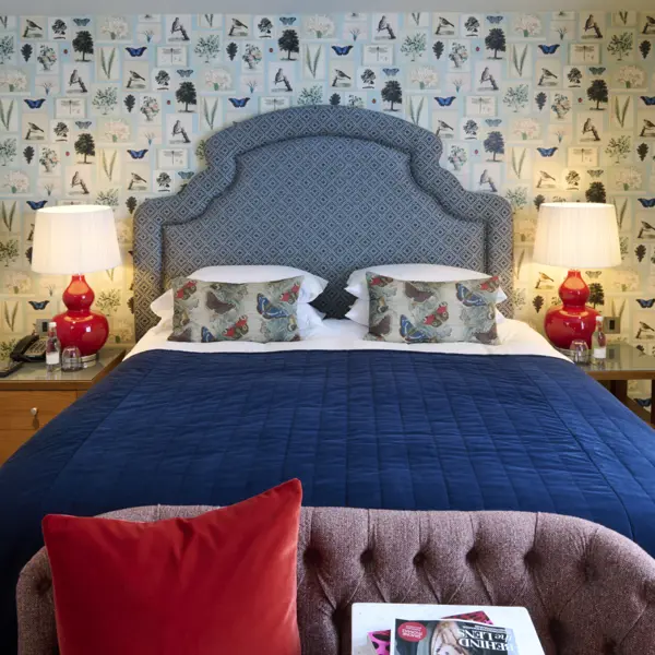 A view of a double bed decorated in dark blue sheets