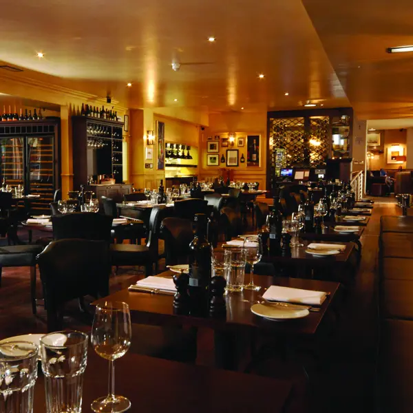 A restaurant featuring tables, chairs, and wine glasses.