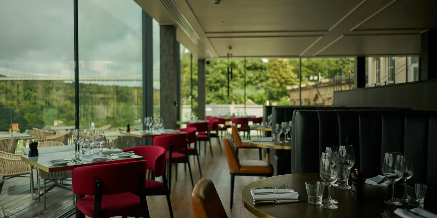 A restaurant featuring tables, chairs, and a spacious window.