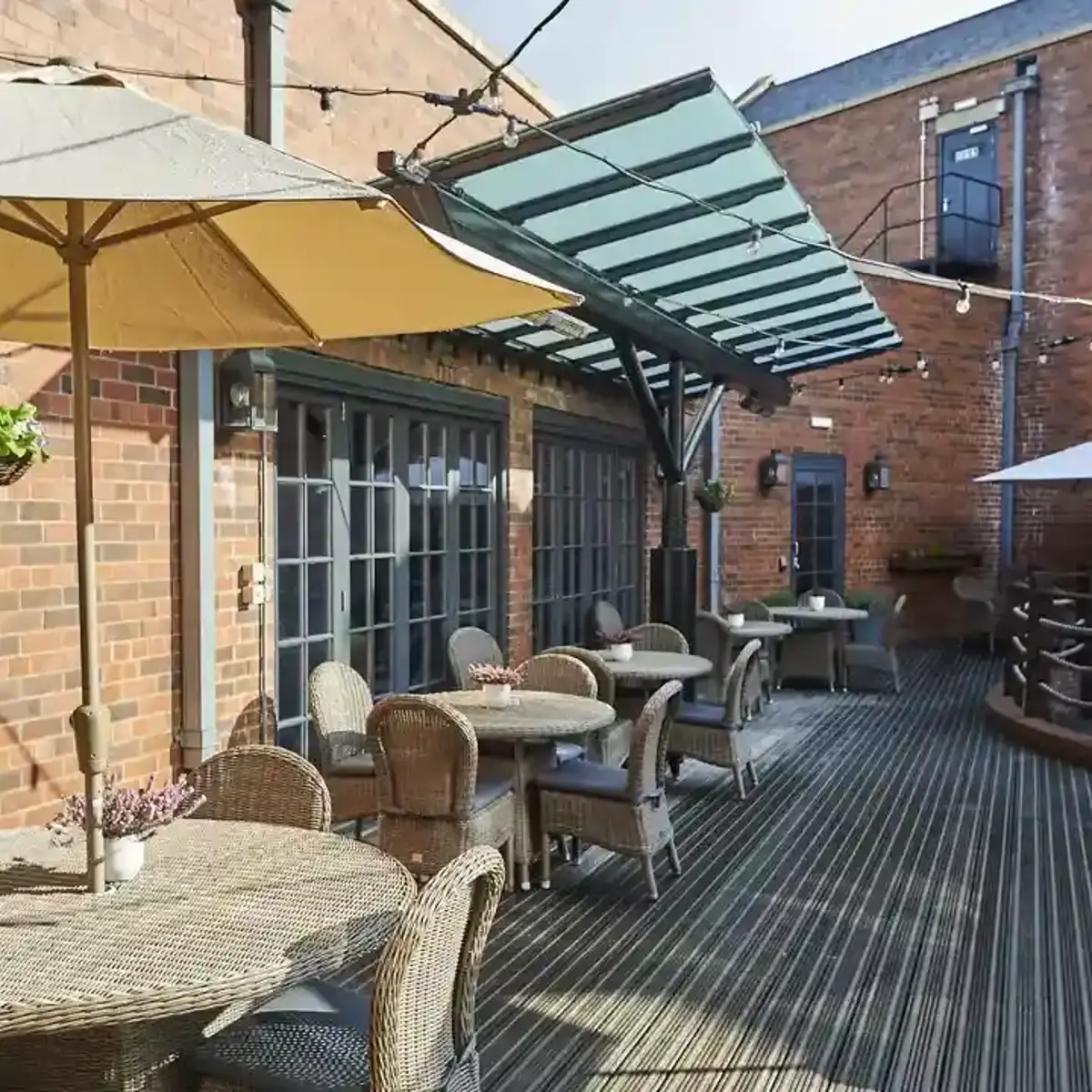 A patio featuring tables, chairs, and umbrellas.