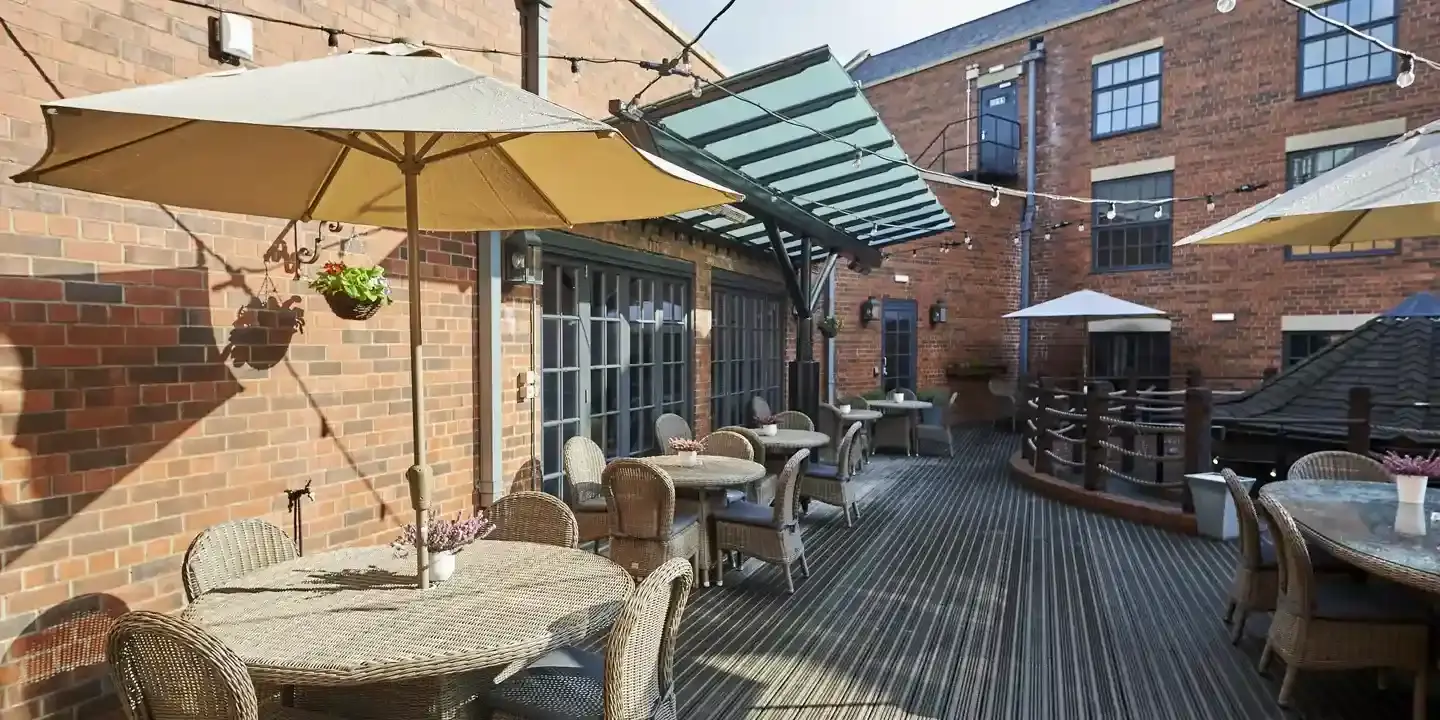A patio featuring tables, chairs, and umbrellas.