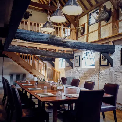 A dining room featuring a wooden table and chairs.