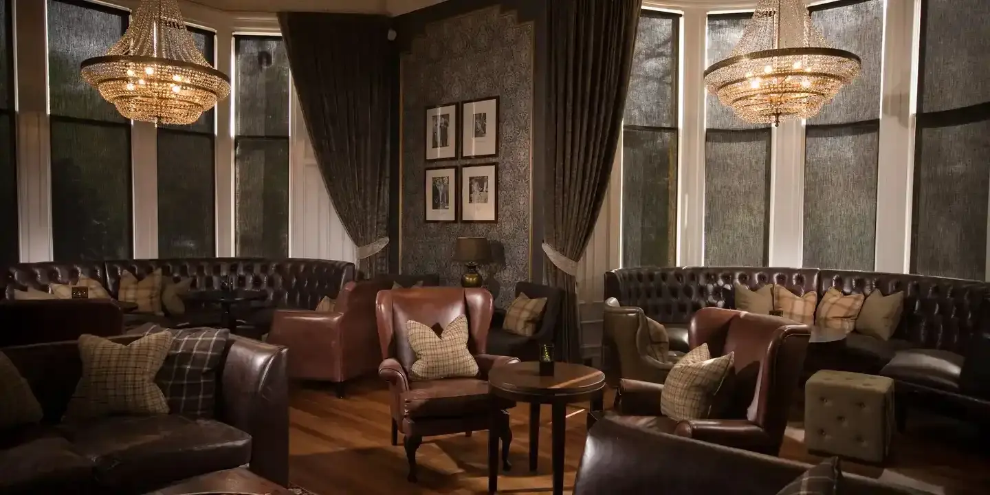 HDV Glasgow Bar with chandelier and brown sofas and armchairs