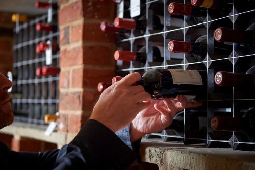 Wine expert selecting a bottle from a cellar