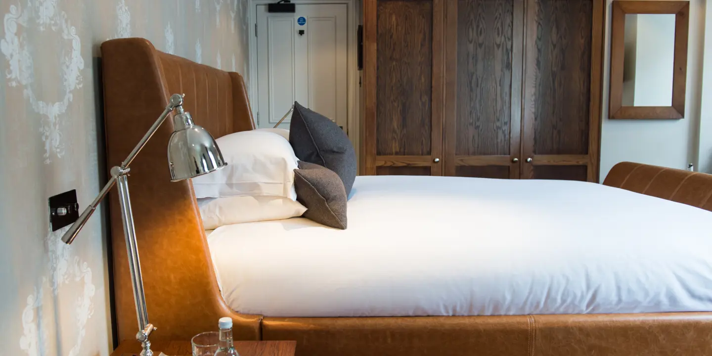 An elegantly furnished bedroom featuring a comfortable bed and a functional desk.