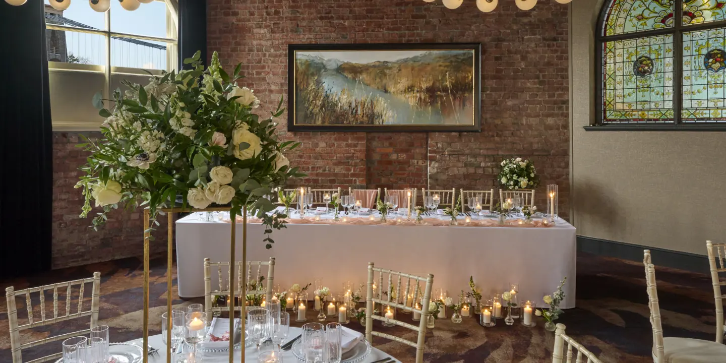 A dining room set with tables and chairs arranged for a dinner gathering.