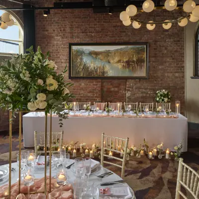 A dining room set with tables and chairs arranged for a dinner gathering.