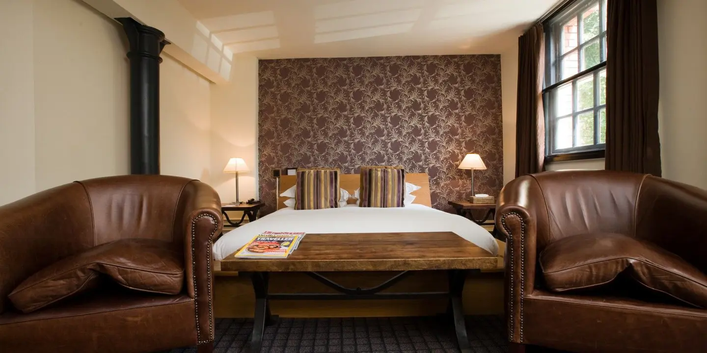 An elegantly furnished hotel room featuring a comfortable bed and a functional desk.