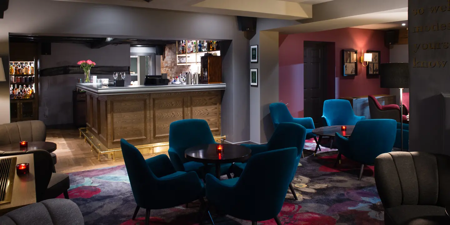 An elegantly furnished room featuring a collection of stylish blue chairs and a sleek bar counter.