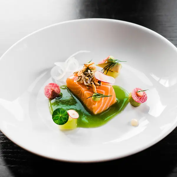 Salmon fillet served on a white plate.