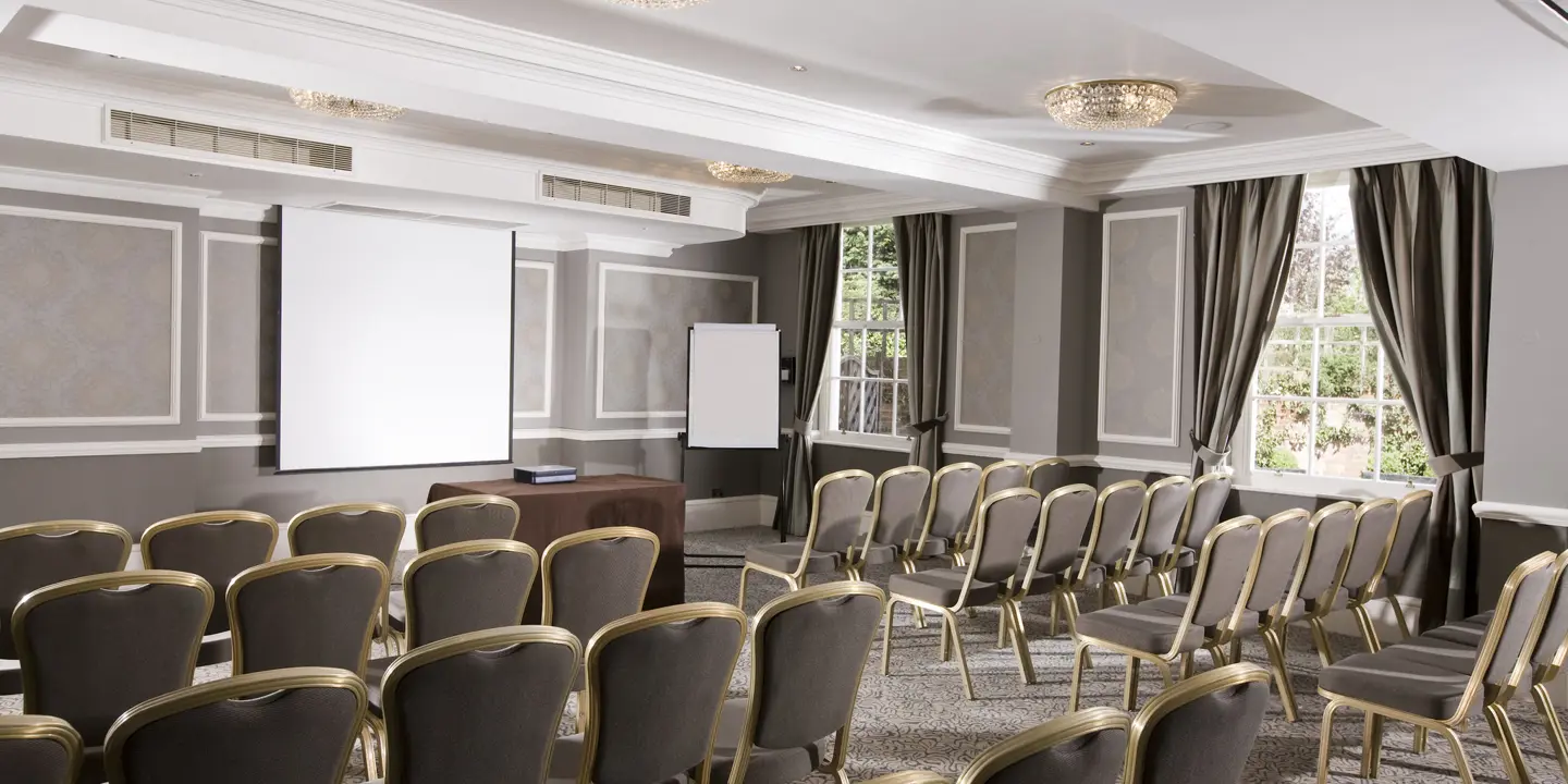 Conference room featuring chairs and a projector screen.