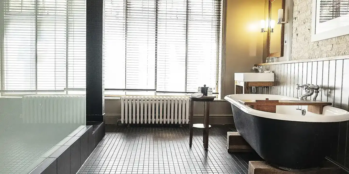 A bathroom featuring a bathtub, sink, and window.