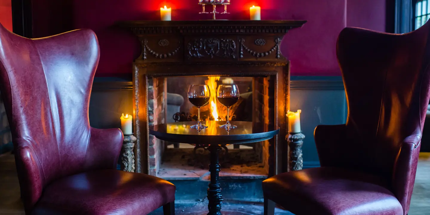 Two chairs positioned in front of a cozy fireplace.